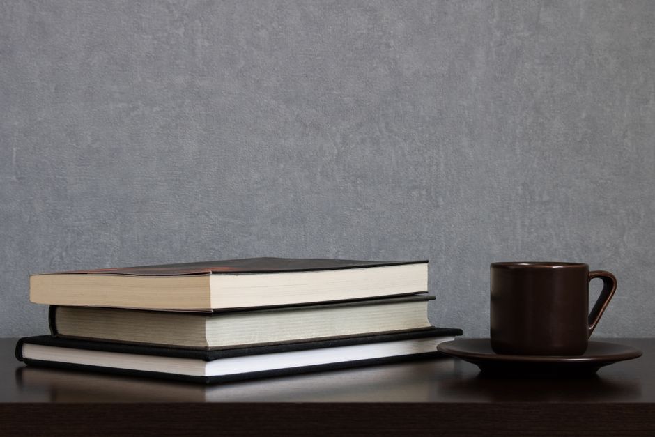 Pile of assorted hardcover books with colorful covers, perfect for study or literature themes.
