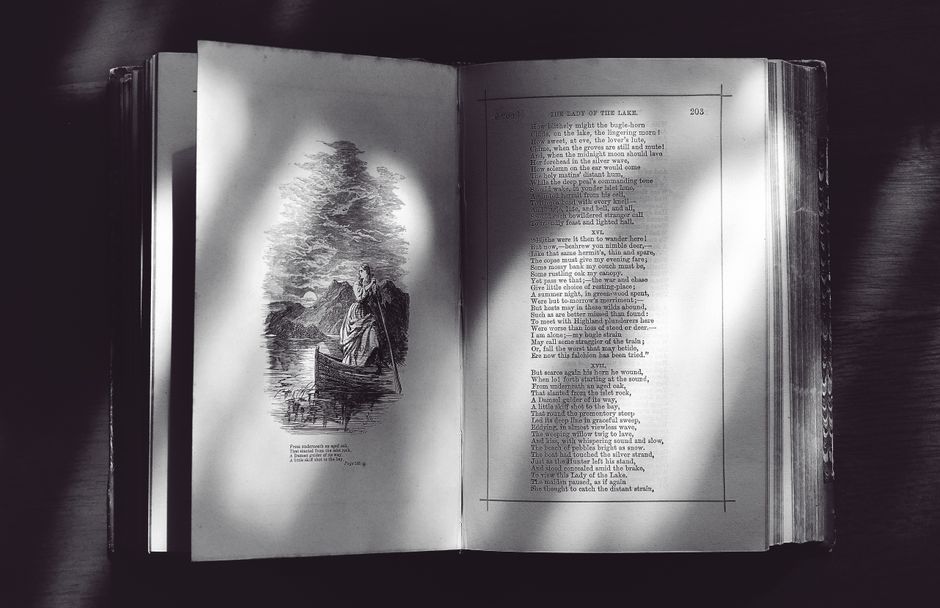 Hand turning a book page, capturing an intimate moment of reading.